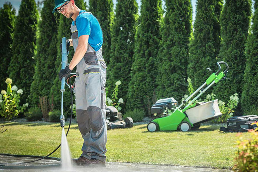 man power washing driveway